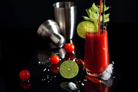 Bloody mary cocktail and ingredients: peper chili, lime, celery, ice and shaker. copy spaceの写真素材