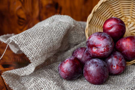 Plum. Fresh plum. Harvest. Autumn harvest. Autumn. Blue plums. Yellow plum. Fresh plums on a wooden surface. Fresh plums on wooden table background.の写真素材