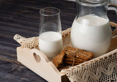Chocolate chip cookies with milk on rustic wooden tableの写真素材