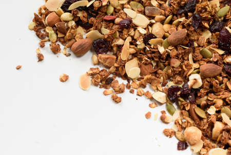 Pile of homemade granola with various seeds and berries shot from above isolated on white backgroundの写真素材
