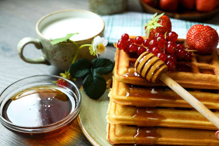 Belgian wafers with honey and fresh berries:  strawberry and red currants.の写真素材