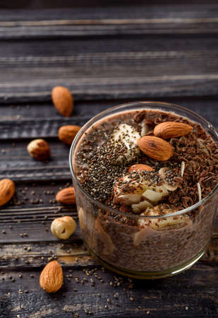 chia pudding with chocolate banana smoothie in a glass jar on the old wooden backgroundの写真素材