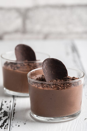 Chocolate mousse in a glasses on a white wooden background.の写真素材
