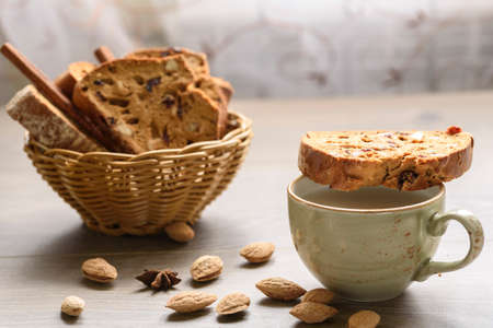 Traditional Italian biscotti Almond Cantuccini in a basket decorated with nuts on wooden tableの写真素材