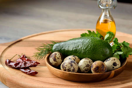 The idea of breakfast. Ingredients for the baked avocado: fresh avocado, quail eggs and greensの写真素材