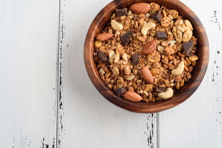 granola in wooden bowl close up isolated on white background.の写真素材