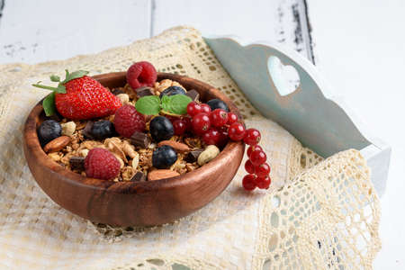 Bowl of homemade granola with yogurt and fresh berries on wooden background.の写真素材