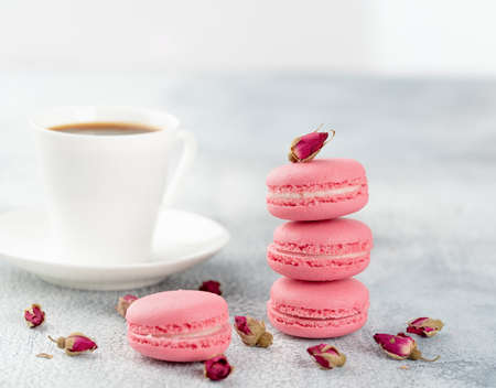 Pink macaroons with dried flower buds and cup of coffee. Pastel coloredの写真素材