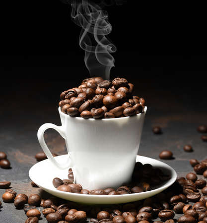 Coffee beans in coffee cup on black background. Place for your tex. Copy spaceの写真素材