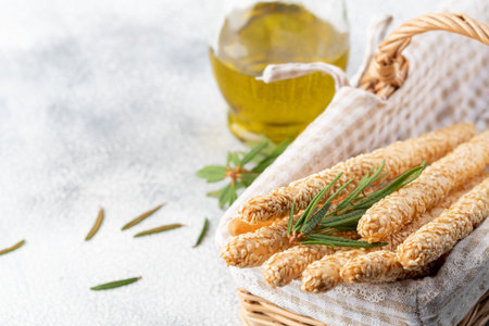 Italian grissini or salted bread sticks in the basket on a light stone background. Fresh italian...