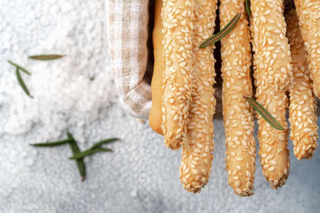 Italian grissini or salted bread sticks in the basket on a light stone background. Fresh italian snack. Copy space.の写真素材