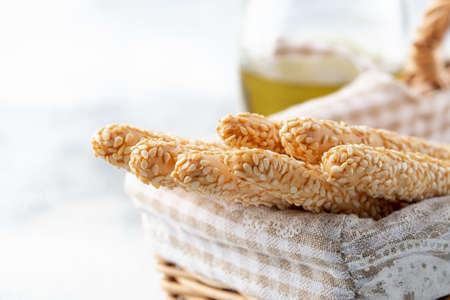 Italian grissini or salted bread sticks in the basket on a light stone background. Fresh italian snack. Copy space.の写真素材