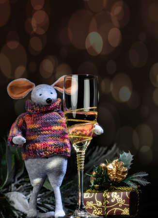 The symbol of the New Year 2020 is the mouse. With a glass of champagne, spruce branches and lights.の写真素材