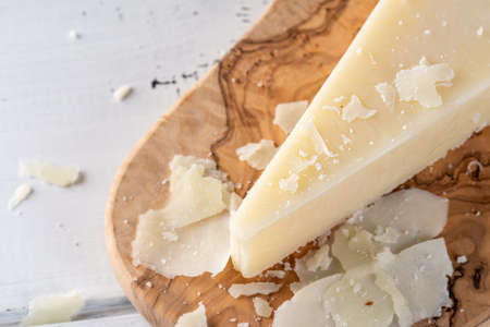 Pecorino romano, hard italian sheep milk cheese on wooden cutting board, selective focus. Copy spaceの写真素材