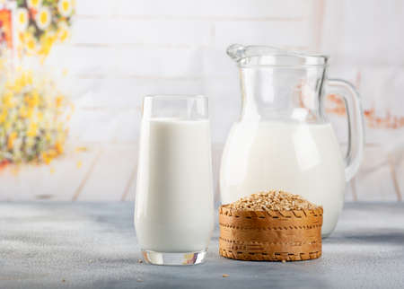 Glass of vegan oat milk and Oat on a table, space for text. Light backgroundの写真素材