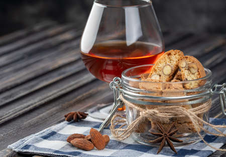 Traditional italian Christmas New Year dry cookies biscuits biscotti cantuccini. Biscotti di Prato with dessert wine. In glass jar.の写真素材