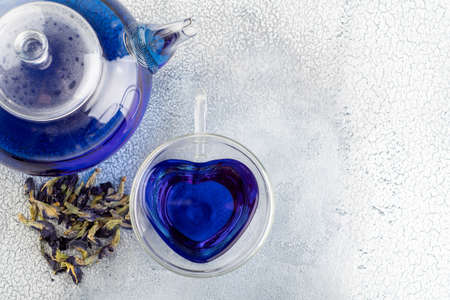 Cup of Butterfly pea tea (pea flowers, blue pea) and tea pot for healthy drinking, detox drinking on Light backgroundの写真素材