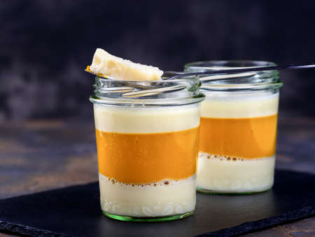 Dessert. Coconut milk panna cotta with mango, italian dessert, homemade on a dark black background. Place for copy spaceの写真素材