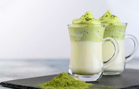 Two cups Dalgona Matcha Latte, a creamy whipped matcha, on light background. Matcha green tea.の写真素材