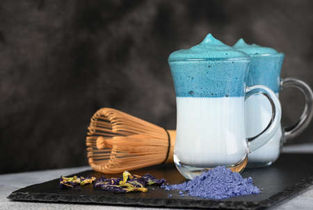 Dalgona Matcha Blue Latte, a creamy whipped matcha in glass on dark background.の写真素材