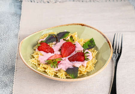 Pasta with strawberry cream and fresh strawberries and basil. High quality photoの写真素材