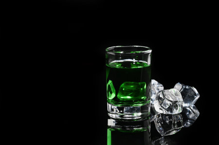 Absinthe shot with ice cube on black background. Close-upの写真素材