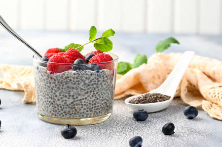Healthy chia pudding with coconut milk and fresh berry in a glass. Light backgroundの写真素材