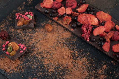 Homemade chocolate with dried berries: raspberries, strawberries and nuts. Dark backgroundの写真素材