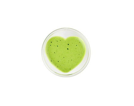 Heart shaped cup of green matcha latte tea isolated on white background.