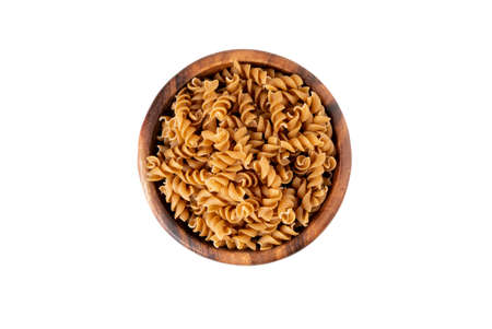 Bowl of wholegrain pasta spirals or fusilli, isolated on white background. Copy spaceの写真素材