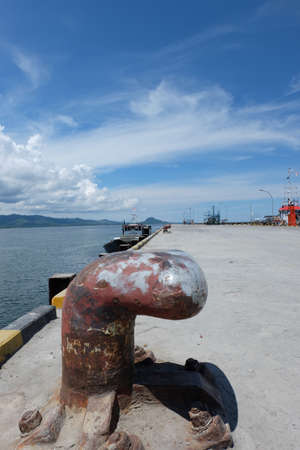 Rusty mooring bollard with ship ropes on seaportの写真素材