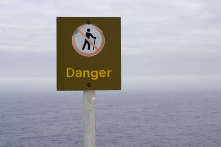 A weathered sign along the cliff face at cape spearの写真素材