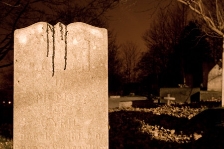 Gravestone in a old graveyard at night. Probably isn't blood, but it sure looks it.の写真素材