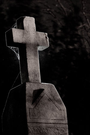 A cross on a tombstone, backlight with a hot shoe flash.の写真素材