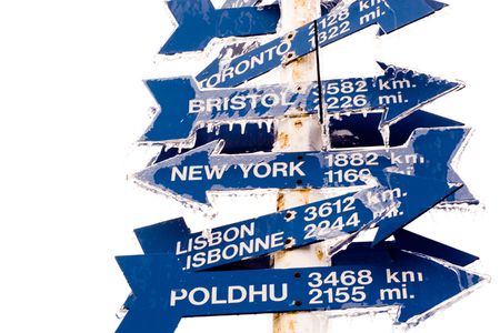 Signpost atop Signal Hill, St. John's, Newfoundland, Canada pointing to key locations around the world, covered in snow. の写真素材