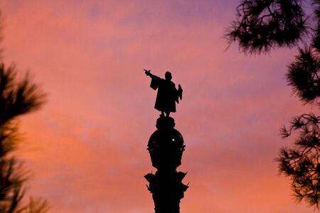 Statue gesturing forward into the sunset near the beach in Barcelona.の写真素材
