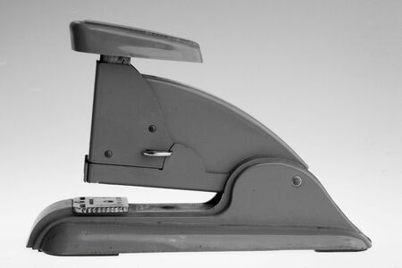 Vintage grey stapler on a grey gradient background. の写真素材