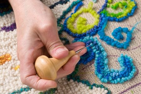 Hooking a mat, a traditional Newfoundland craft that recyles old fabrics into vibrant mats using burlap. の写真素材