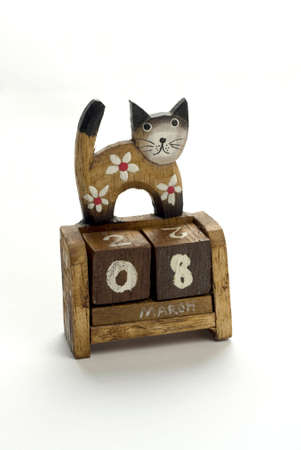 Wooden calendar with a cat who is standing on it.の写真素材