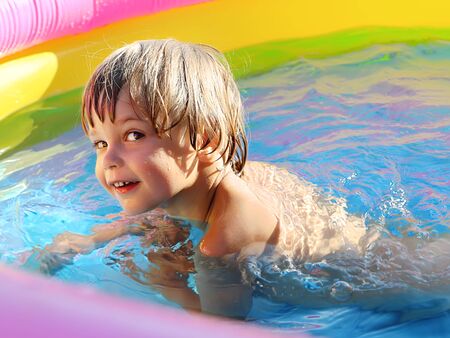 Tanned cheerful boy practicing swimming in the pool.の写真素材