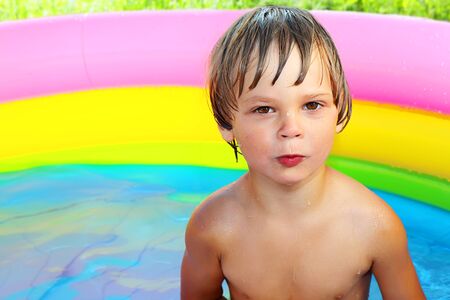 Tanned cheerful boy practicing swimming in the pool.の写真素材
