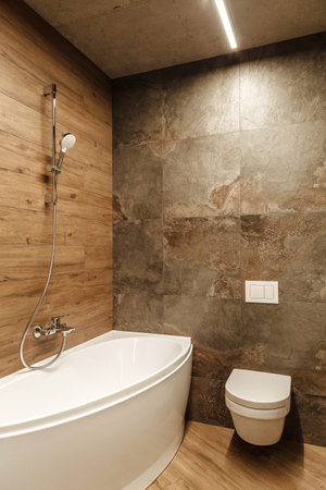 bathroom in a style loft with tiles imitation wood and stone in warm colors with a corner white...