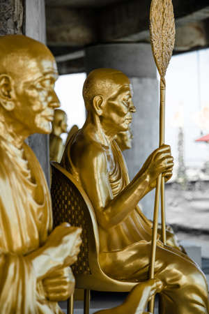 Thailand - 2019. Phra Phutta Ming Mongkol Akenakiri. Golden elders sitting in a row in meditation with blurred background.のeditorial素材