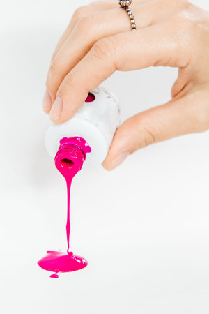 Female hand with pink nail polish on white background, close-up