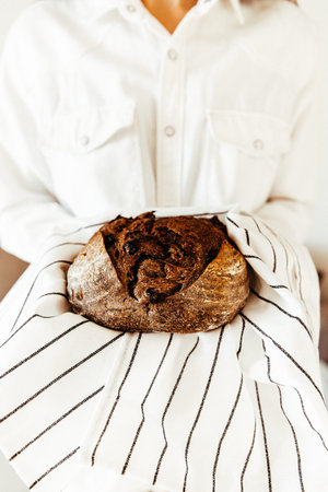 Bread in the hands of a young woman in a white shirt