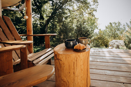 two cups of coffee and croissants on a wooden table, outdoorsの写真素材