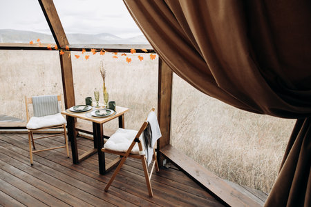 Table and chairs in a restaurant with a view of the mountains.の写真素材