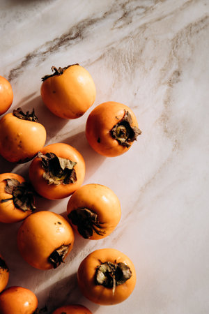 Fresh ripe persimmons on a marble countertop. Healthy eating conceptの写真素材