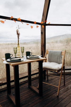 Wooden terrace with table and chairs in autumnal setting. Autumn season.の写真素材