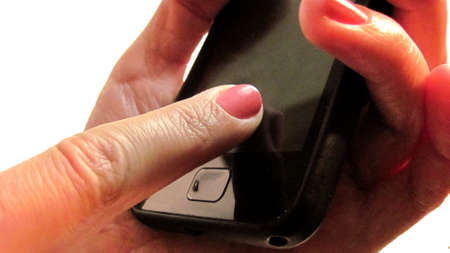 One hand holds the phone and the other hand with the index finger touches the screen                               の写真素材